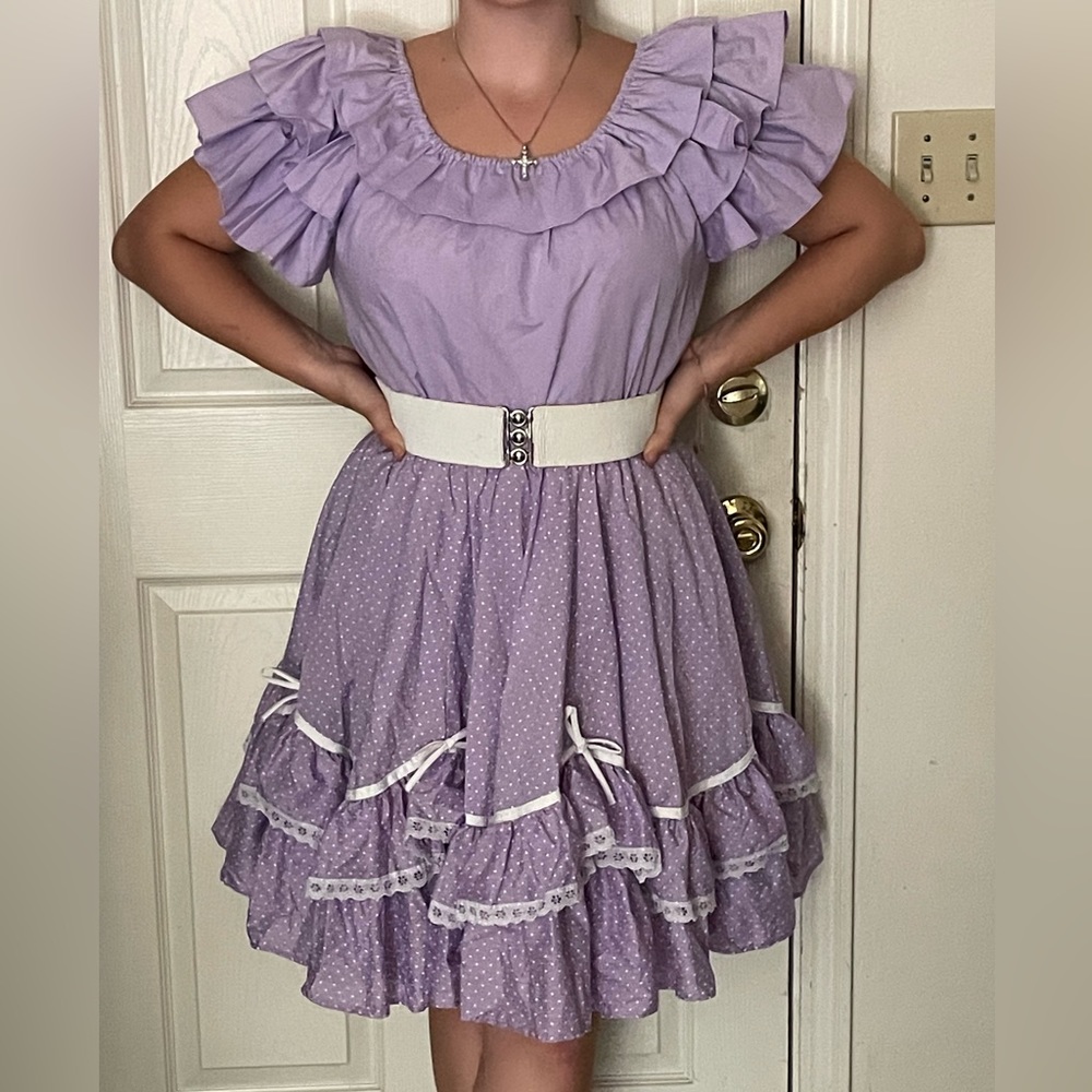 Purple puffy sleeved top with purple polka-dot skirt.